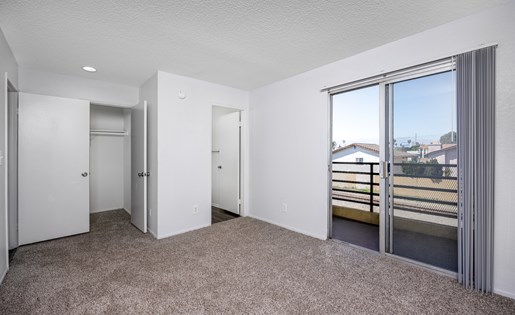A spacious room with a view of the outside through a large window.